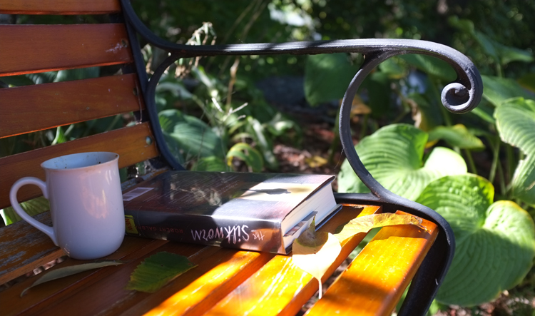 coffee and book on a bench